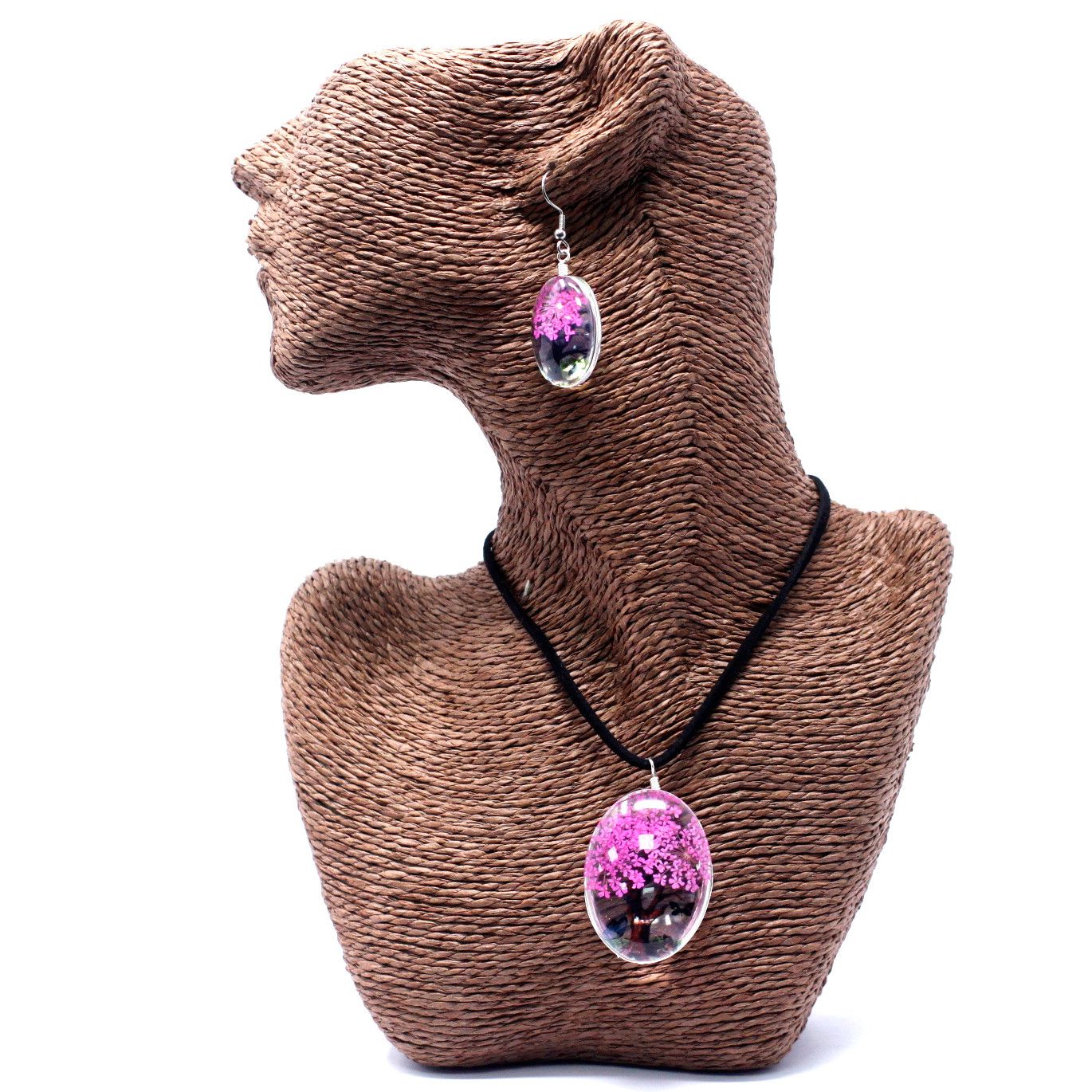 Necklace with a pink pendant on a brown textured stand against a white background