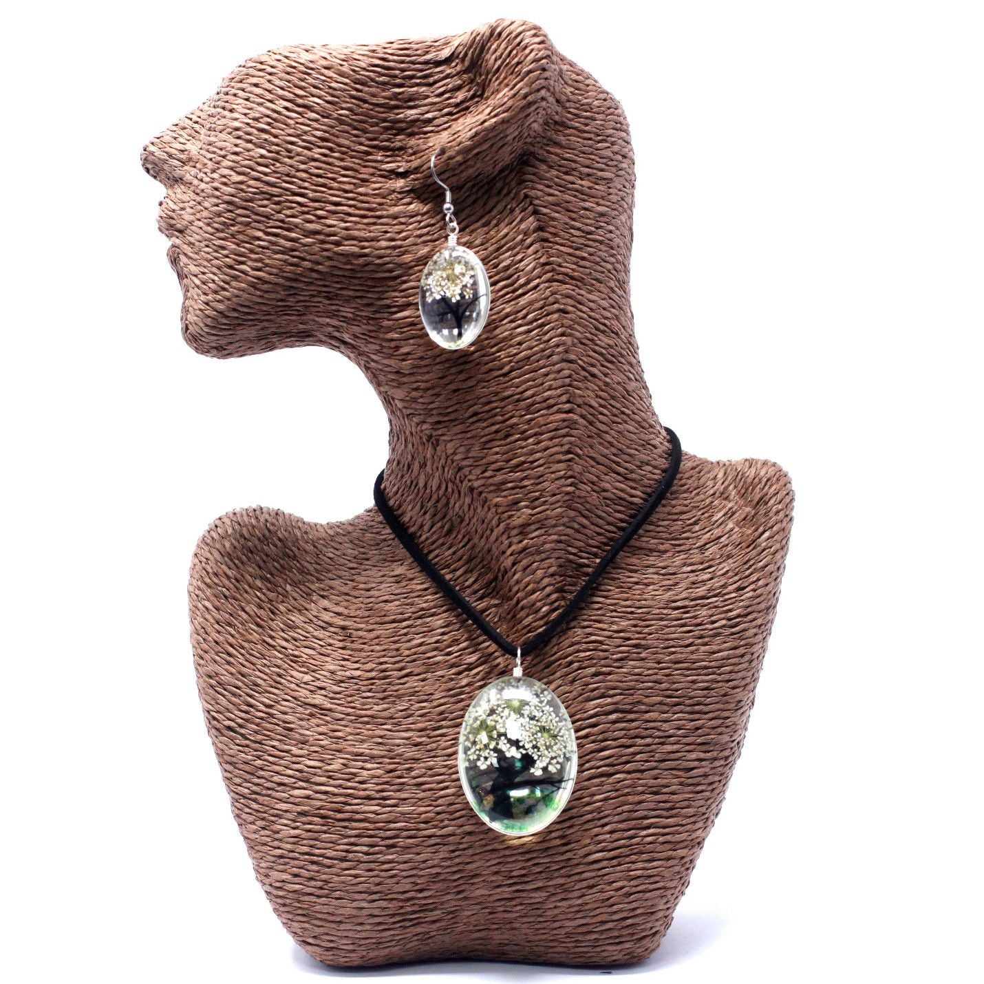 Necklace with a pendant on a brown textured stand against a white background
