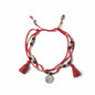 Red bracelet with tassels and a coin charm on a white background