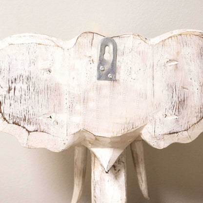 White distressed elephant head wall decoration on a plain background