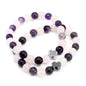 Two beaded bracelets with purple and white beads and silver star-shaped charms on a white background.