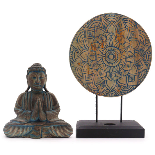 Wooden Buddha statue and decorative mandala plate on a white background
