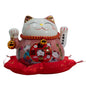 Decorative cat figurine with red pillow on a white background